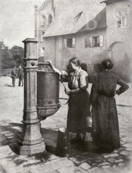 Kašny: stojánek na pitnou vodu, lidově zvaný kašnička nebo pumpička, na rohu Hroznové a Panské ulice, asi 1924, sbírka J. Dvořáka; SOkA.